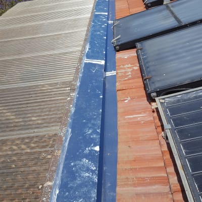 תעלת ניקוז כחולה על גג רעפים אדומים