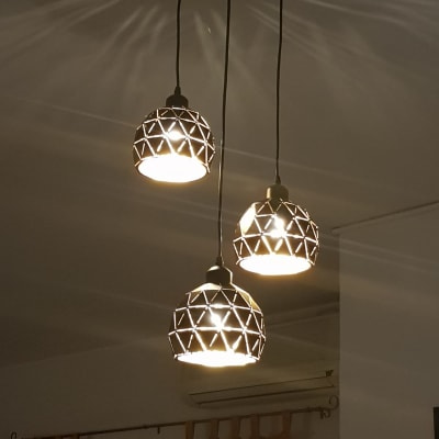 שלושה גופי תאורה תלויים עם עיצוב גיאומטרי