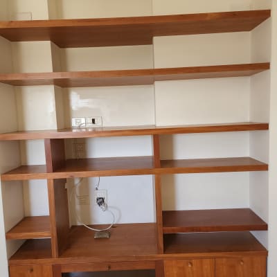 מדפים מעץ על רקע קיר צבוע בלבן