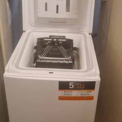 מכונת כביסה עם פתח עליון פתוח ותווית אחריות