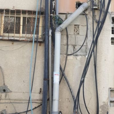 צינורות פלסטיק ואביזרי אינסטלציה על קיר חיצוני