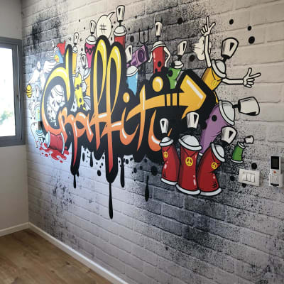 גרפיטי צבעוני על קיר לבנים עם פחיות צבע