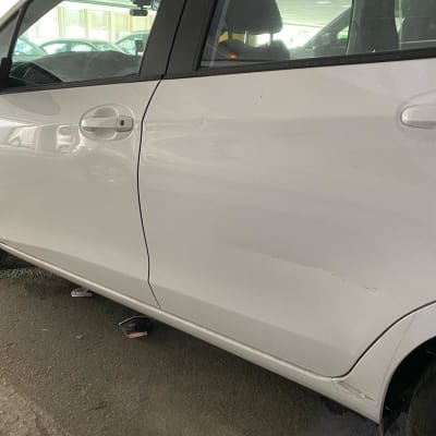 דלת רכב לבנה עם שריטות קלות בצד