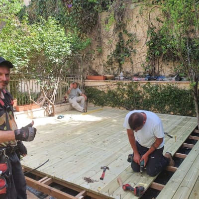 בניית דק עץ בגינה עם כלים ועובדים