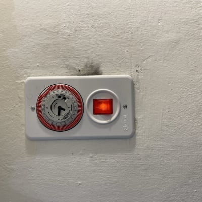 שעון טיימר חשמלי עם מתג מואר על קיר