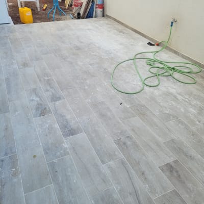 צינור ירוק על רצפה מלוכלכת עם כלי ניקוי