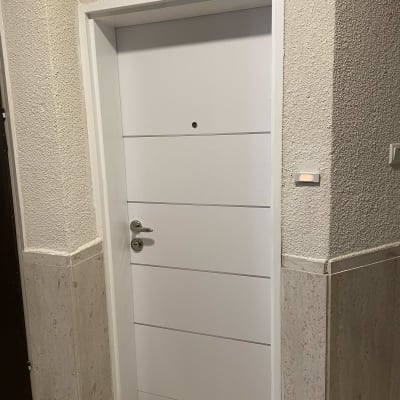 דלת לבנה עם ידית כסופה ומנעול