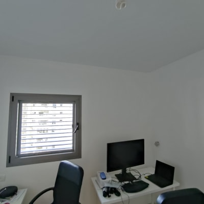 חדר עם שולחן מחשב, מסך ומחשב נייד