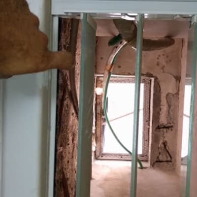 Plumber working on pipes through a window opening