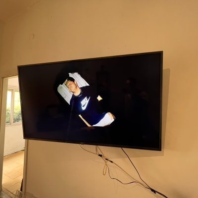 טלוויזיה תלויה על הקיר עם כבלים חשופים