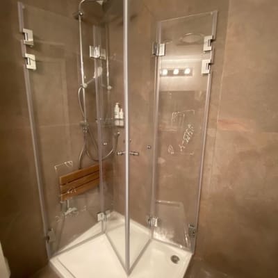 מקלחון זכוכית עם מדף עץ ומקלחת יד