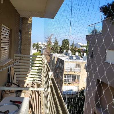 רשת הגנה מותקנת על מרפסת למניעת כניסת יונים