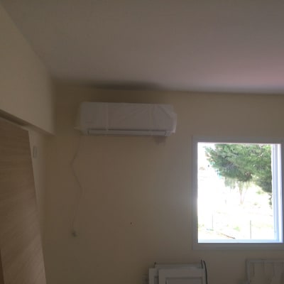 מזגן מותקן על קיר מעל חלון בחדר