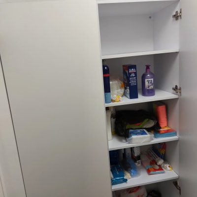 ארון פתוח עם מדפים, מלא במוצרי ניקוי