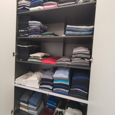 ארון בגדים מסודר עם חולצות ומכנסיים מקופלים