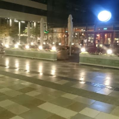 Outdoor area with lights and planters at night
