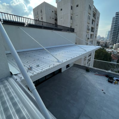 גג עם כיסוי פלסטיק שקוף ומעקה מתכת