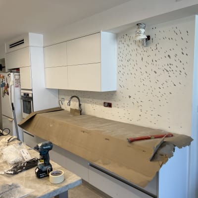 מטבח בשיפוץ עם כלים וחומרים על השיש