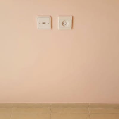 קיר צבוע בצבע ורוד בהיר עם שקעי חשמל