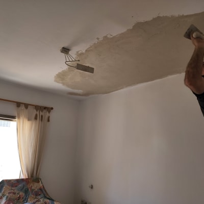 אדם צובע תקרה עם שפכטל