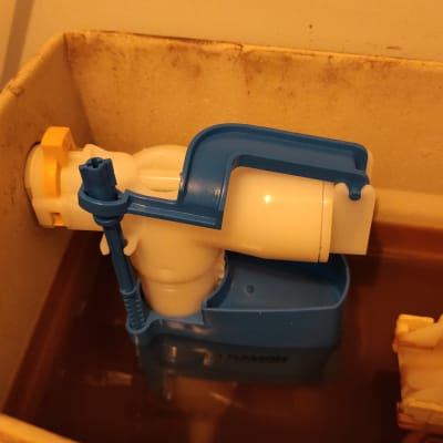 מנגנון מצוף פלסטיק כחול בלבן בתוך מיכל שירותים