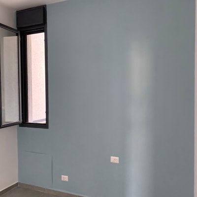 קיר צבוע בצבע כחול בהיר עם חלון פתוח