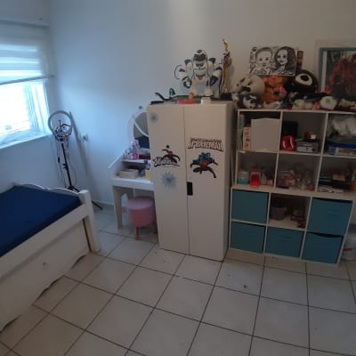 חדר ילדים עם ארון צעצועים ומדפים מאורגנים