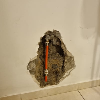 צינור כתום בקיר שבור עם חיבורים