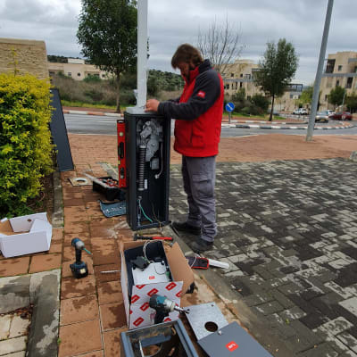 אדם מתקין שער חשמלי עם כלים וציוד