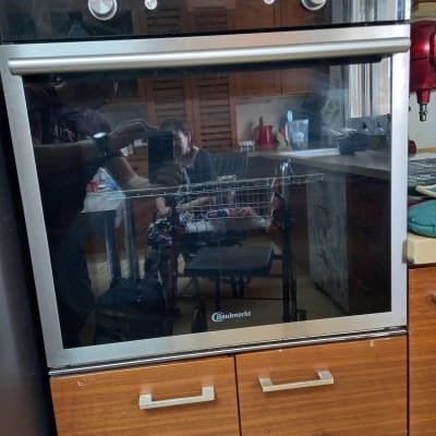 תנור אפייה עם כפתורי שליטה ומסגרת מתכתית