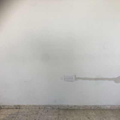 שקע חשמל כפול על קיר לבן עם תיקון טיח