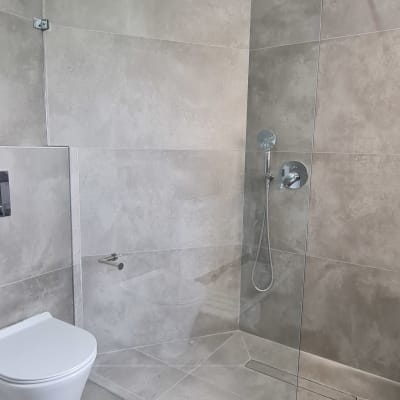 מחיצת זכוכית במקלחת עם מוט מתכת