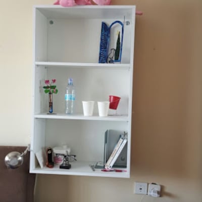 מדף עץ לבן עם חפצים שונים עליו