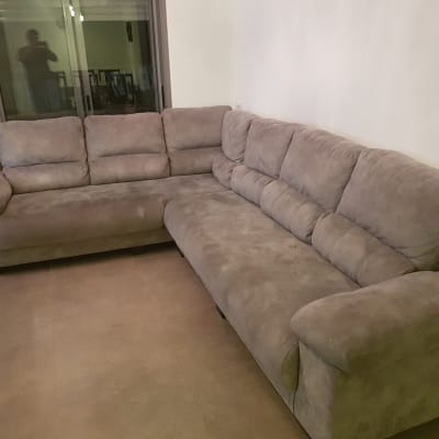 ספה פינתית מרופדת בבד אפור בחדר מגורים