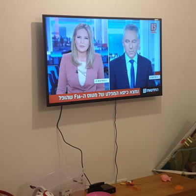 טלוויזיה תלויה על הקיר עם כבלים חשופים
