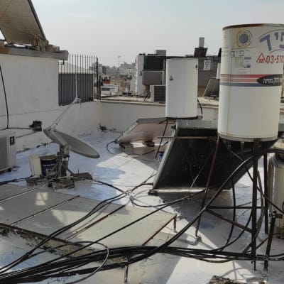 גג עם חומר איטום לבן, דודי שמש וקולטים