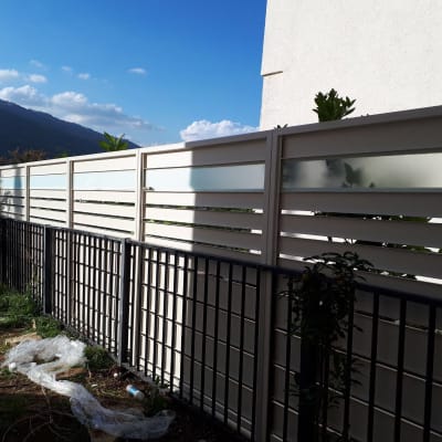 גדרות מתכת ולוחות זכוכית חלבית בחצר