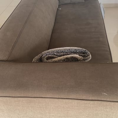 ספה חומה עם כריות ושמיכה מקופלת