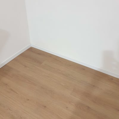 רצפת פרקט עץ בהירה ליד קיר לבן