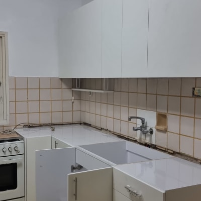 מטבח עם ארונות פתוחים, כיור וברז מותקנים