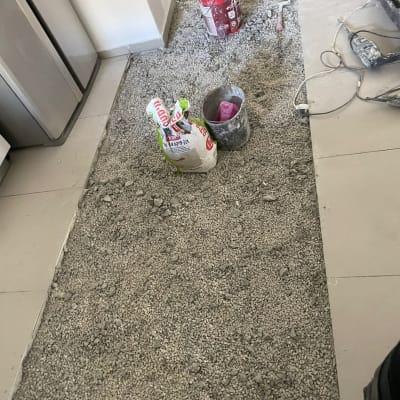 חצץ על הרצפה, דלי צבע, שק מלט וכלי עבודה