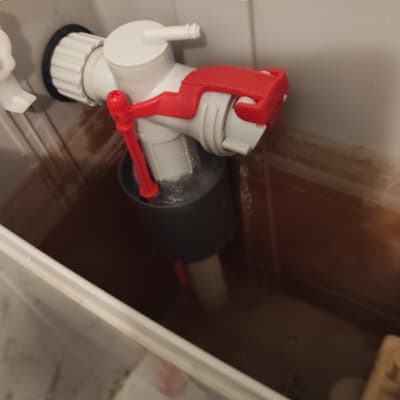 מנגנון מצוף אדום ולבן בתוך מיכל הדחה