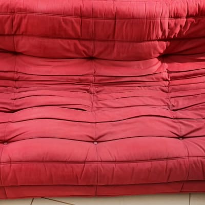 ספה אדומה עם קפלים על רצפה מרוצפת