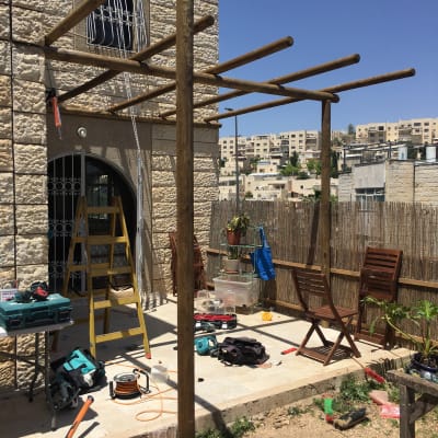 מבנה עץ בבנייה עם כלים וחומרים בגינה