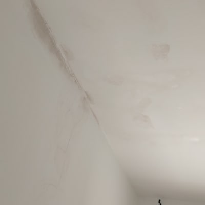 כתמי צבע על תקרה וקיר לבנים