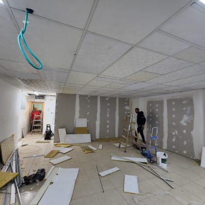 עבודות גבס בחדר עם לוחות וכלים על הרצפה