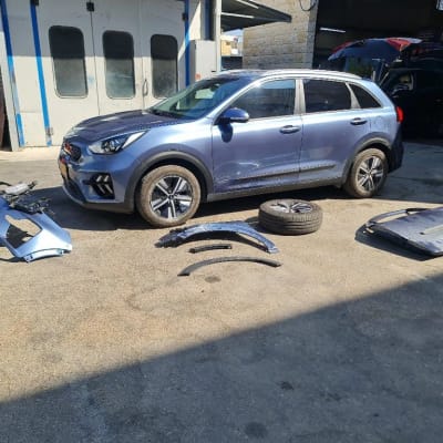 רכב כחול עם חלקי פגוש וגלגל על הקרקע