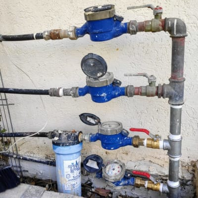 מד מים כחול עם ברזים וצינורות