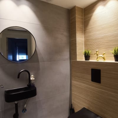 שירותים מודרניים עם כיור שחור ותאורה שקועה