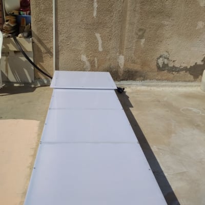 שלושה לוחות לבנים מונחים על רצפה ליד קיר